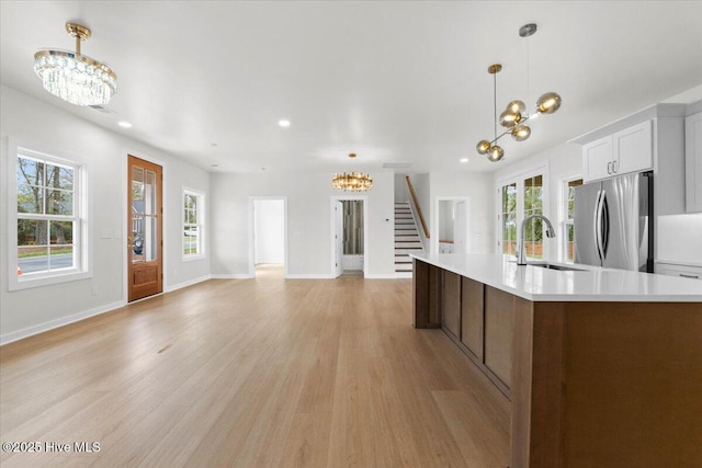 355 S Middleton Dr NW, Calabash, NC 28467 - kitchen featuring a chandelier, freestanding refrigerator, a sink, light countertops, and light wood finished floors