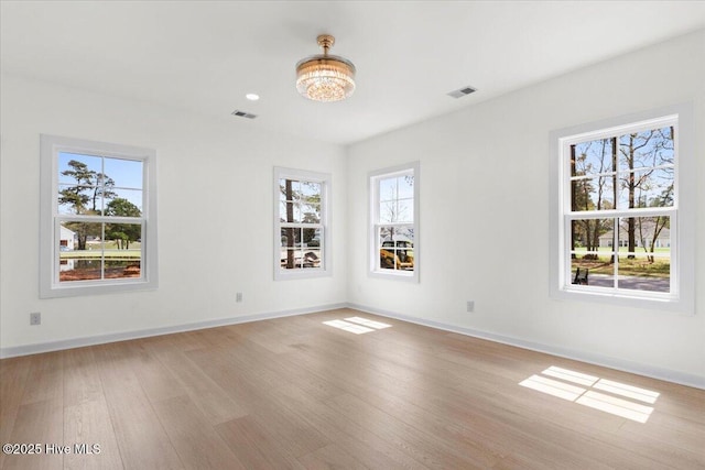 355 S Middleton Dr NW, Calabash, NC 28467 - unfurnished room featuring light wood finished floors, baseboards, and a chandelier