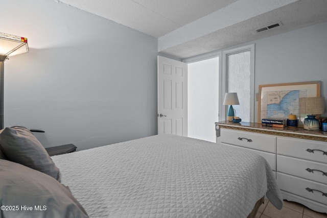 bedroom with light tile patterned flooring and a textured ceiling