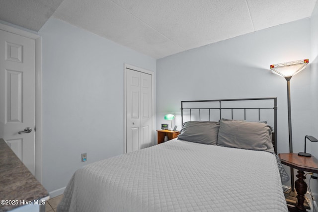 bedroom featuring a closet, a textured ceiling, and baseboards
