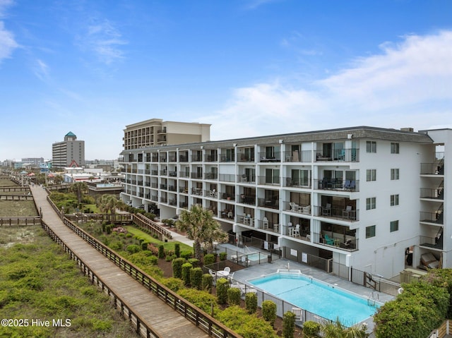 view of apartment building / complex with a community pool and fence