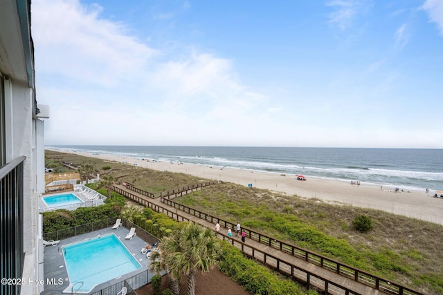 water view featuring nearby beach and fence