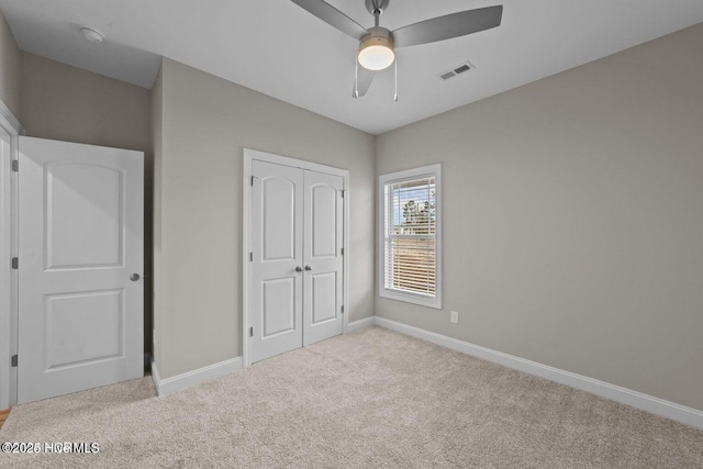 unfurnished bedroom featuring carpet floors, baseboards, and a closet