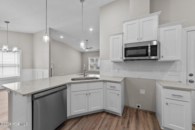 kitchen featuring appliances with stainless steel finishes, a sink, dark wood-style floors, white cabinets, and lofted ceiling