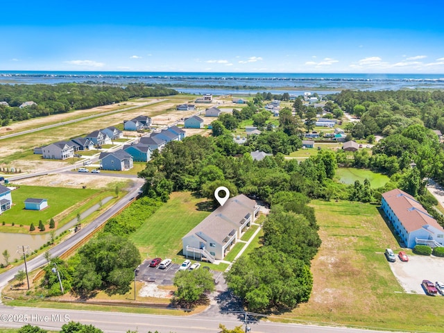 aerial view of residential area featuring a large body of water and a tree filled landscape