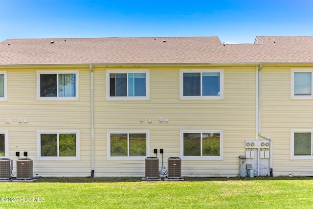 back of house featuring central AC unit and a yard