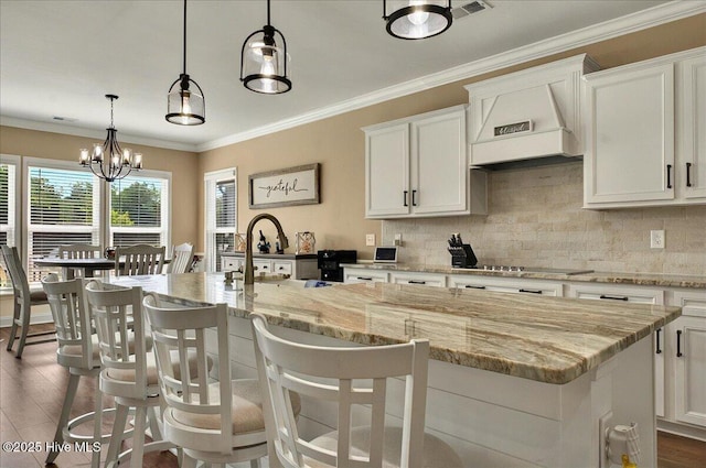 97 Eagle Claw Dr, Calabash, NC 28467 - kitchen with white cabinetry, black electric stovetop, a kitchen island with sink, backsplash, and a sink