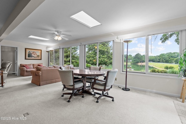 106 Millstone Rd, West End, NC 27376 - dining space featuring light colored carpet, a skylight, a ceiling fan, and baseboards