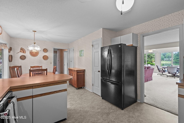 106 Millstone Rd, West End, NC 27376 - kitchen with freestanding refrigerator, wallpapered walls, light colored carpet, a chandelier, and decorative light fixtures