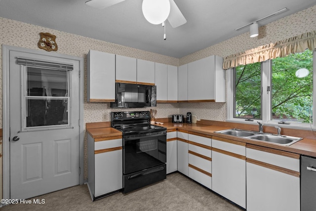 106 Millstone Rd, West End, NC 27376 - kitchen featuring black appliances, a sink, wallpapered walls, a ceiling fan, and white cabinets