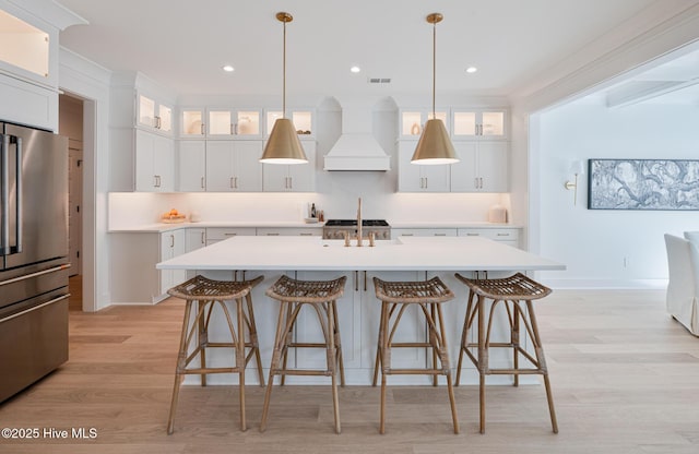 kitchen with freestanding refrigerator, custom range hood, light wood-style floors, light countertops, and recessed lighting