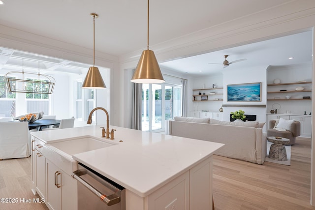 kitchen featuring stainless steel dishwasher, light wood-type flooring, plenty of natural light, a sink, and beam ceiling