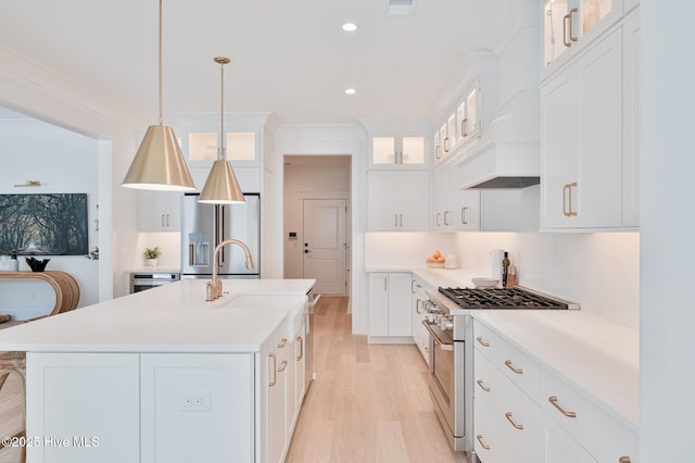 kitchen featuring appliances with stainless steel finishes, light wood-style flooring, light countertops, a sink, and recessed lighting