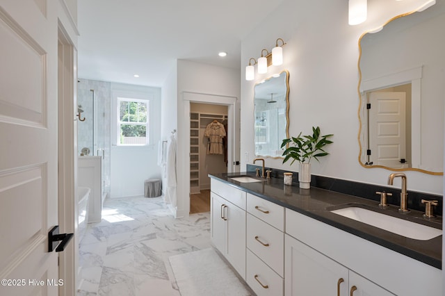 full bathroom with a stall shower, a walk in closet, recessed lighting, marble finish floors, and double vanity