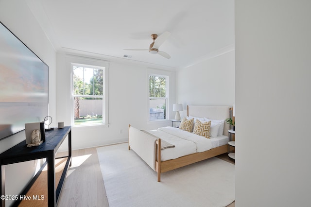 bedroom with wood finished floors, baseboards, ceiling fan, and crown molding