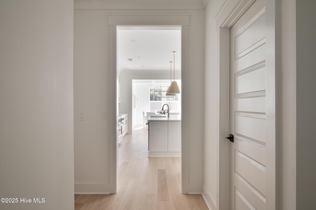 hallway with light wood-style floors and baseboards