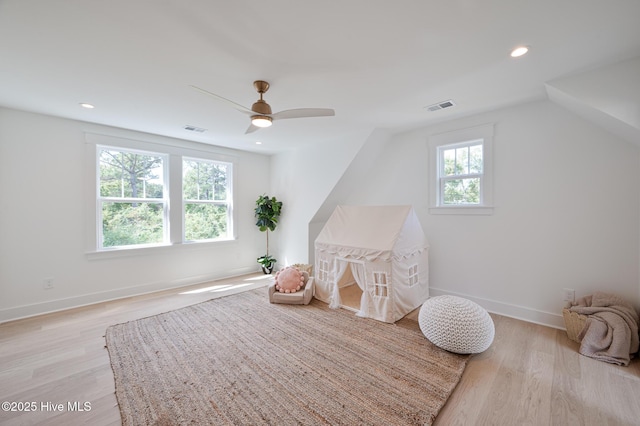 rec room featuring light wood finished floors, a ceiling fan, baseboards, recessed lighting, and vaulted ceiling