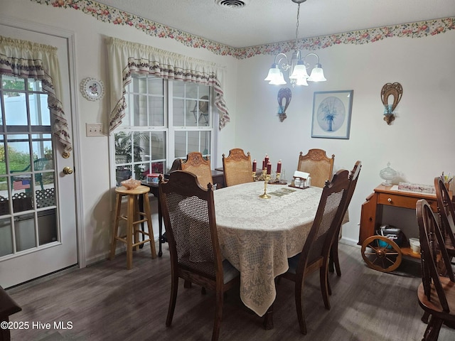 dining room with a chandelier, wood finished floors, and baseboards