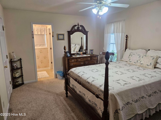carpeted bedroom with connected bathroom, baseboards, and a ceiling fan