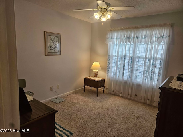 living area featuring ceiling fan, carpet floors, a textured ceiling, and baseboards