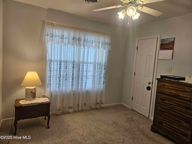 living area featuring carpet, a ceiling fan, and baseboards