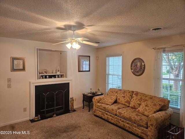 living room featuring a ceiling fan, carpet floors, a textured ceiling, and baseboards