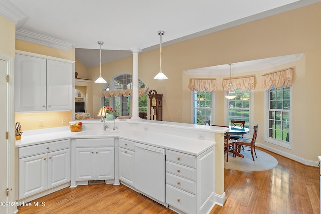 kitchen featuring dishwasher, a sink, a peninsula, light wood-style floors, and white cabinets