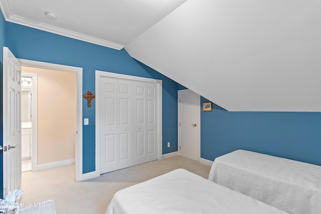 carpeted bedroom featuring vaulted ceiling, baseboards, and a closet