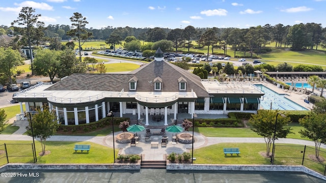 back of property featuring a fire pit, a yard, and view of wooded area