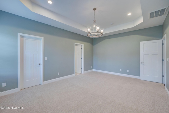 carpeted spare room with a chandelier, baseboards, a raised ceiling, and recessed lighting