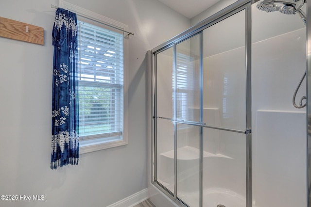 bathroom featuring a stall shower and baseboards