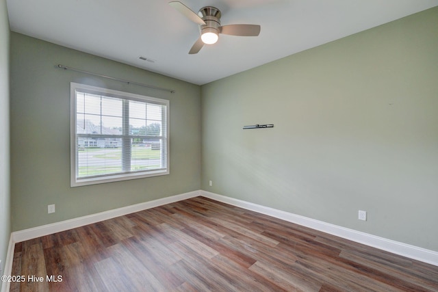 unfurnished room featuring wood finished floors, a ceiling fan, and baseboards