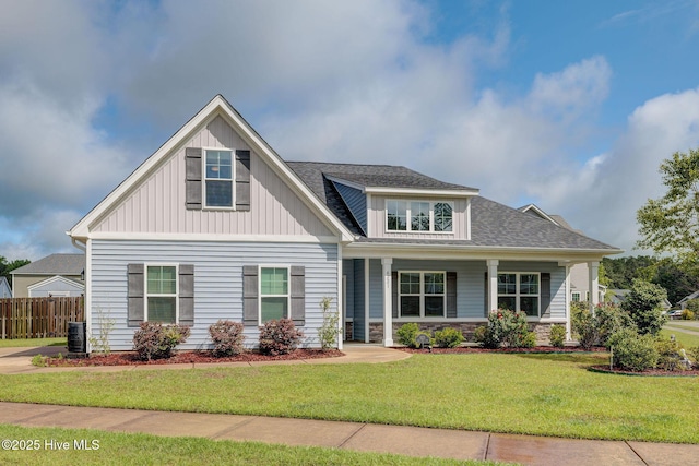 craftsman house with central air condition unit, board and batten siding, stone siding, and a porch