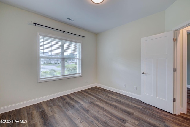 unfurnished room featuring dark wood-style floors and baseboards