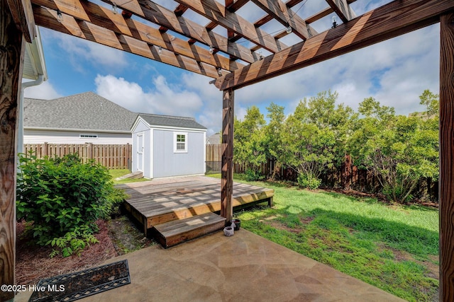 view of yard with a storage shed, an outdoor structure, a pergola, a wooden deck, and a patio