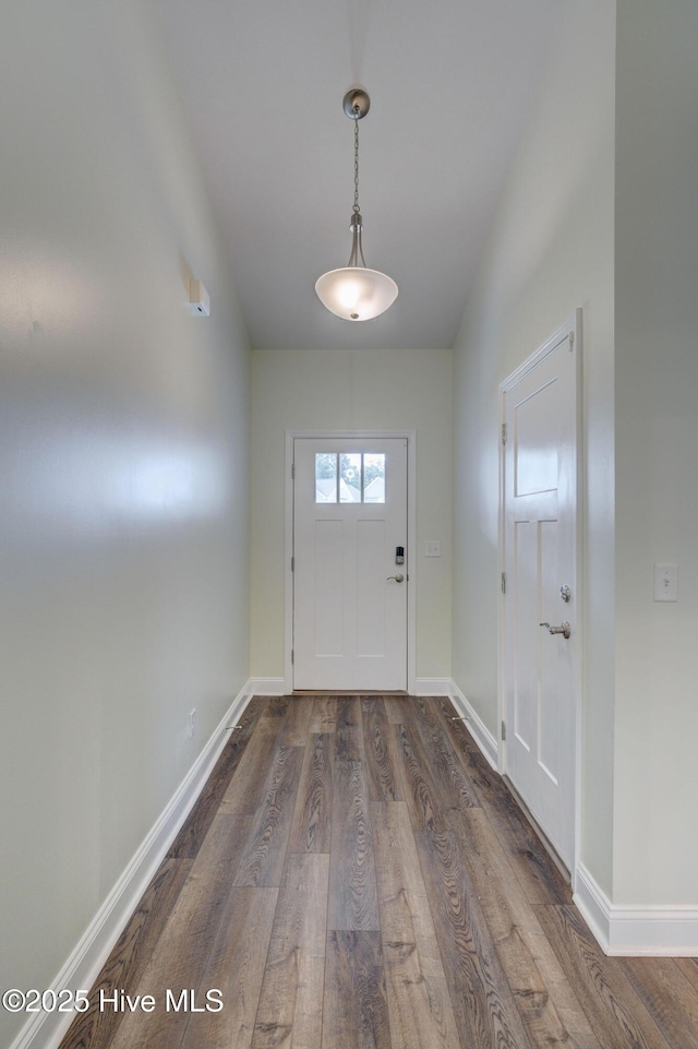 doorway featuring dark wood-style flooring and baseboards