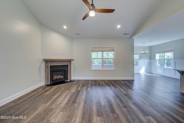 unfurnished living room with a fireplace, a chandelier, dark wood finished floors, lofted ceiling, and ceiling fan