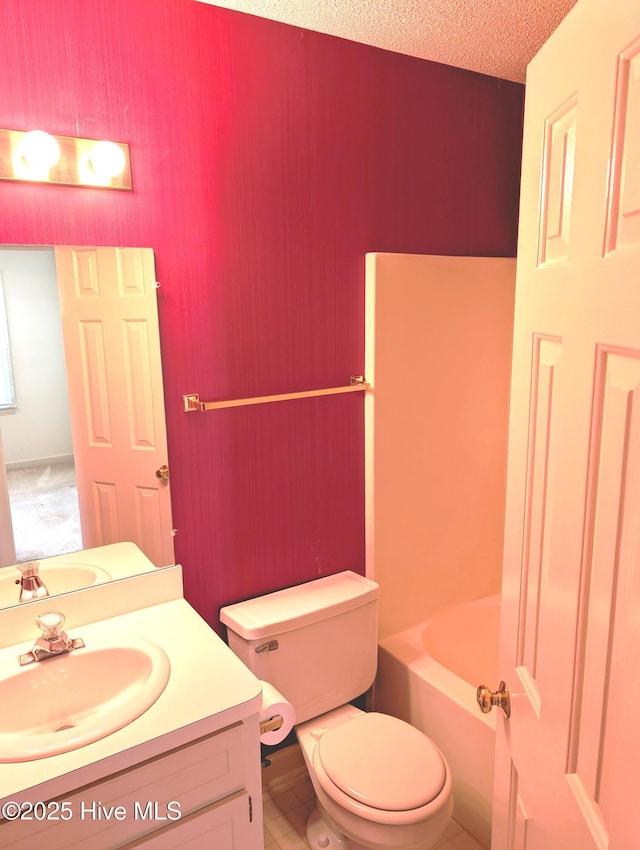bathroom with toilet, vanity, a tub to relax in, and a textured ceiling