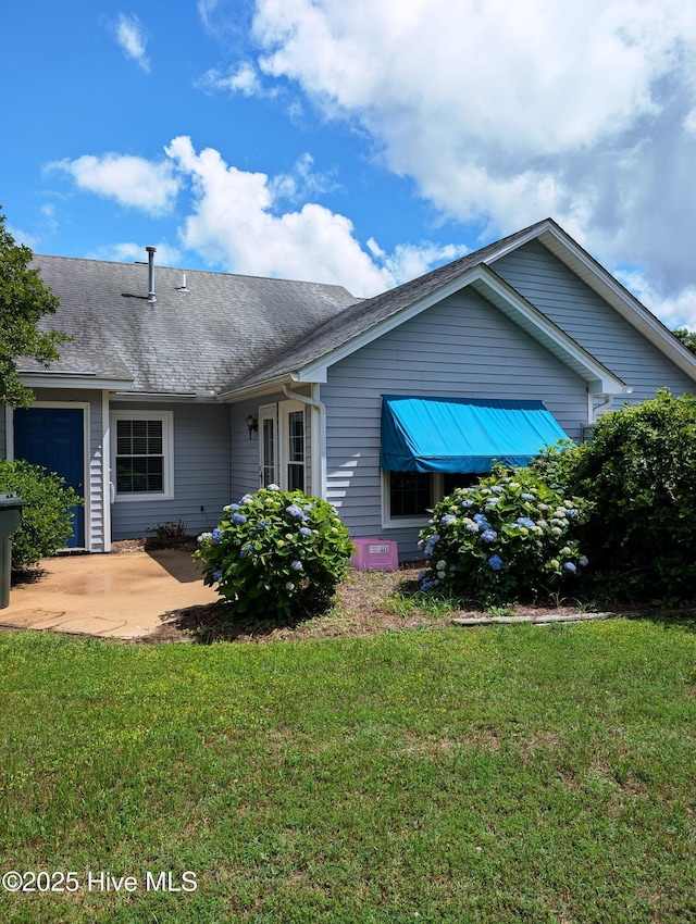 ranch-style house with a front yard and a patio area