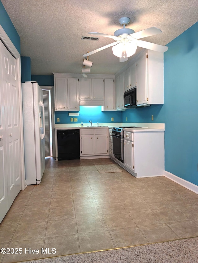 kitchen featuring black appliances, a textured ceiling, light countertops, a ceiling fan, and a sink