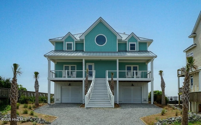 30 Porpoise Pl, North Topsail Beach, NC 28460 - coastal inspired home with a standing seam roof, board and batten siding, driveway, and stairs