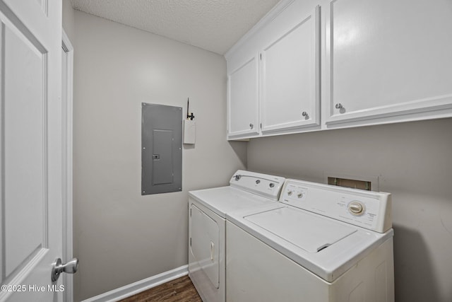 laundry room with electric panel, washing machine and dryer, cabinet space, dark wood-style flooring, and a textured ceiling