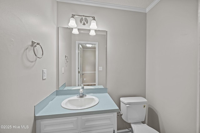 bathroom featuring toilet, vanity, and crown molding