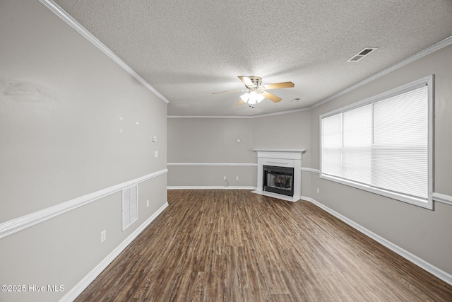 unfurnished living room with a ceiling fan, a fireplace with flush hearth, wood finished floors, a textured ceiling, and ornamental molding