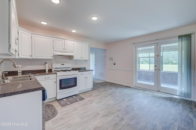 15554 US Highway 421, Burgaw, NC 28425 - kitchen featuring white range with gas stovetop, a sink, under cabinet range hood, dark countertops, and white cabinets