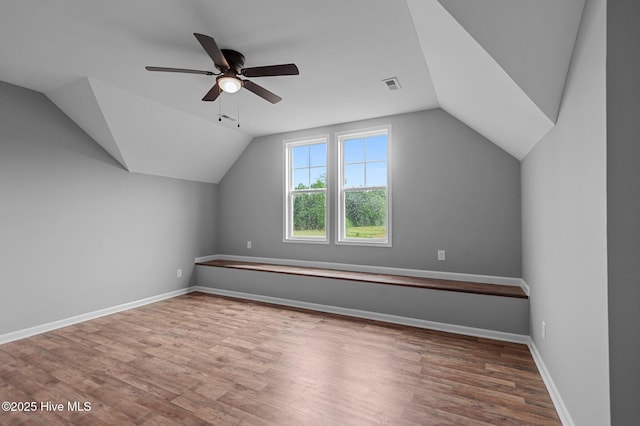 additional living space with ceiling fan, lofted ceiling, wood finished floors, and baseboards