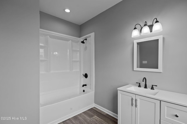 bathroom with wood finished floors, shower / tub combination, baseboards, vanity, and recessed lighting