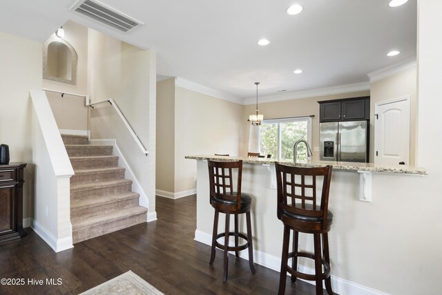 202 Bungalow Rd, Holly Ridge, NC 28445 - kitchen with stainless steel fridge with ice dispenser, a breakfast bar, light stone counters, recessed lighting, and dark wood-style flooring