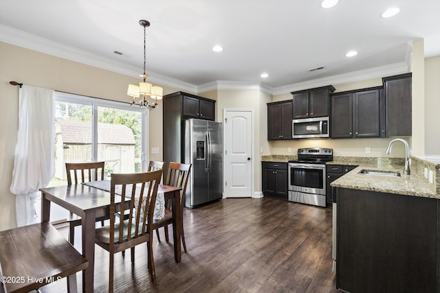 202 Bungalow Rd, Holly Ridge, NC 28445 - kitchen featuring appliances with stainless steel finishes, a sink, light stone countertops, a chandelier, and dark wood-type flooring