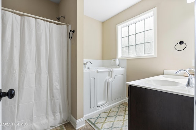 202 Bungalow Rd, Holly Ridge, NC 28445 - bathroom with a sink, a garden tub, curtained shower, and baseboards